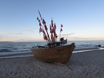 ImageBoot mit roten Fahnen am Strand