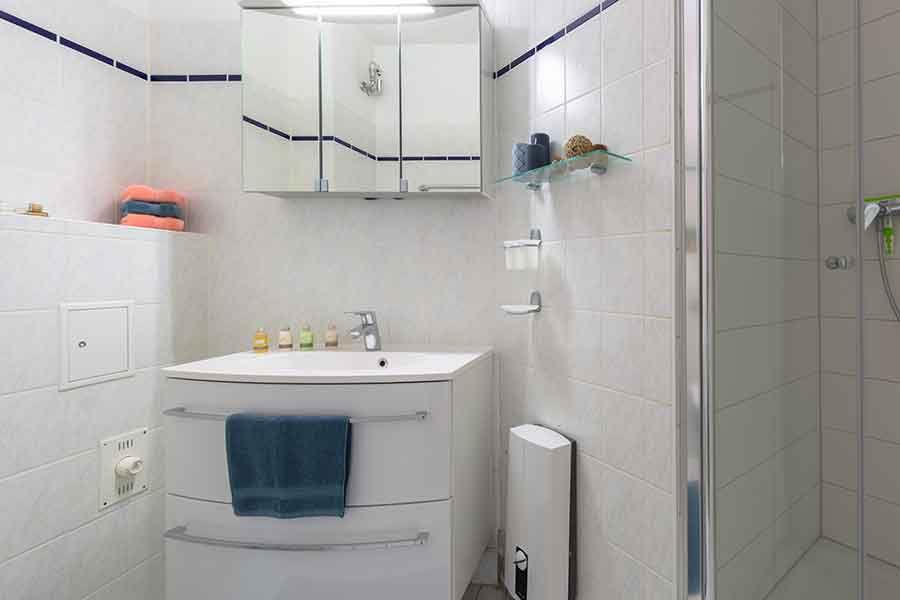 Badezimmer mit Toilette, Waschbecken und Spiegelschrank