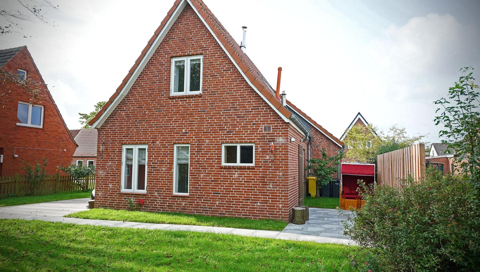 Rotes Backsteingebäude mit Gartenterrasse und rotem Pavillon.