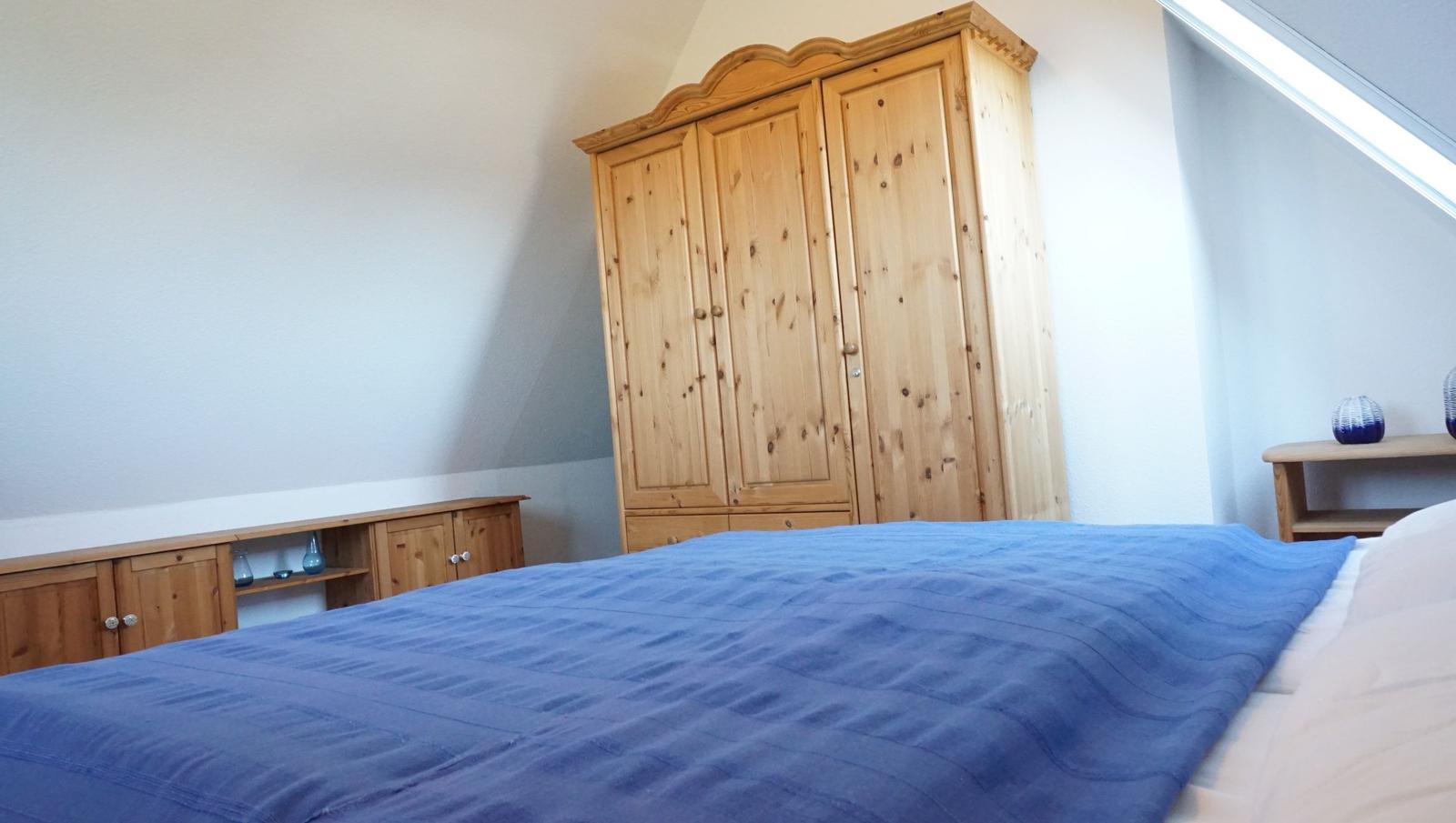 Schlafzimmer mit Holzschrank, Bett und Nachttisch