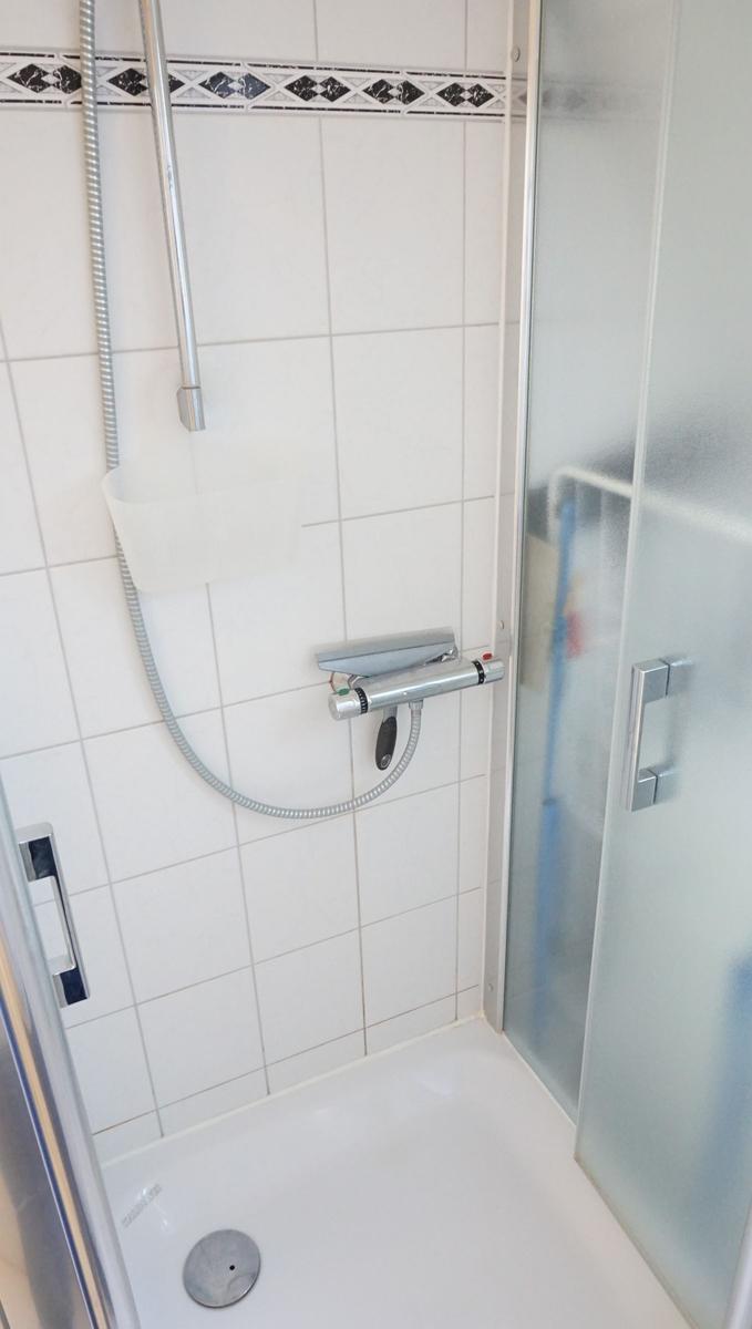Dusche mit Duschbrause und Glastür