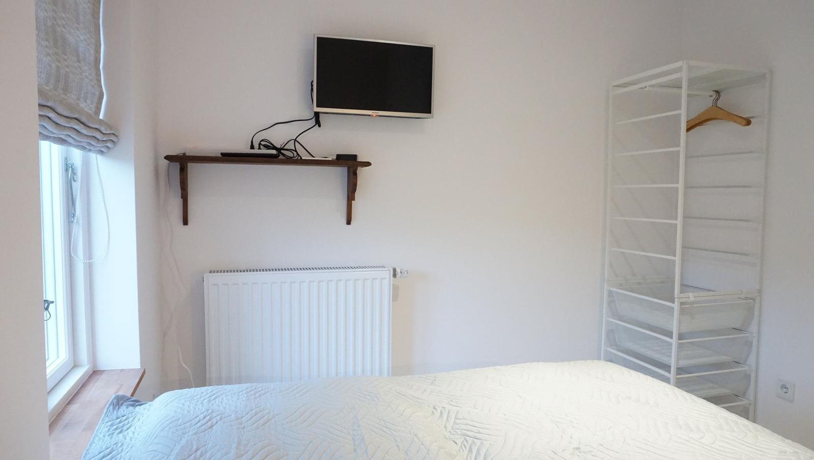 Schlafzimmer mit Bett, TV und Kleiderschrank