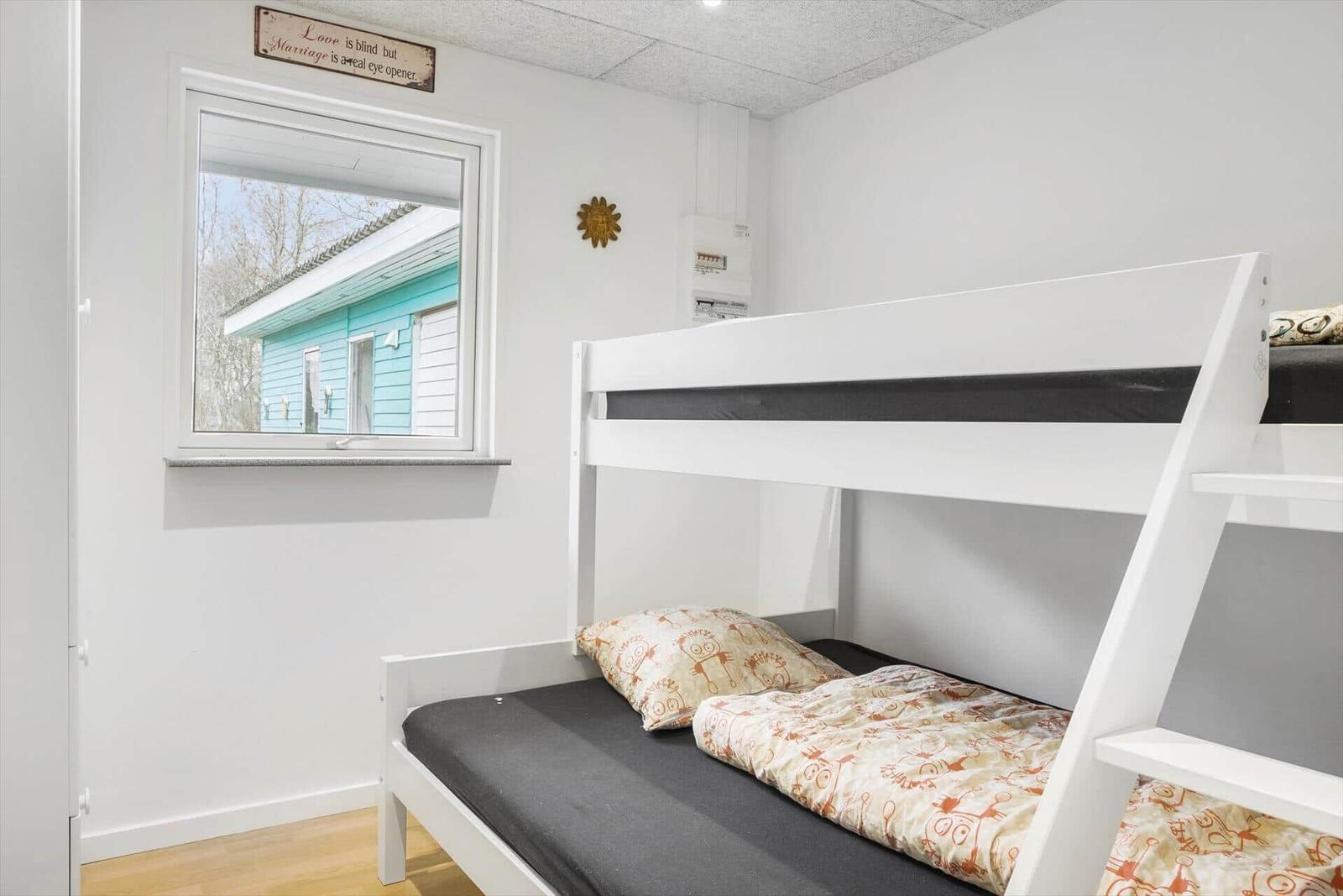 Zimmer mit Doppelstockbett, Fenster und Wanddekoration.