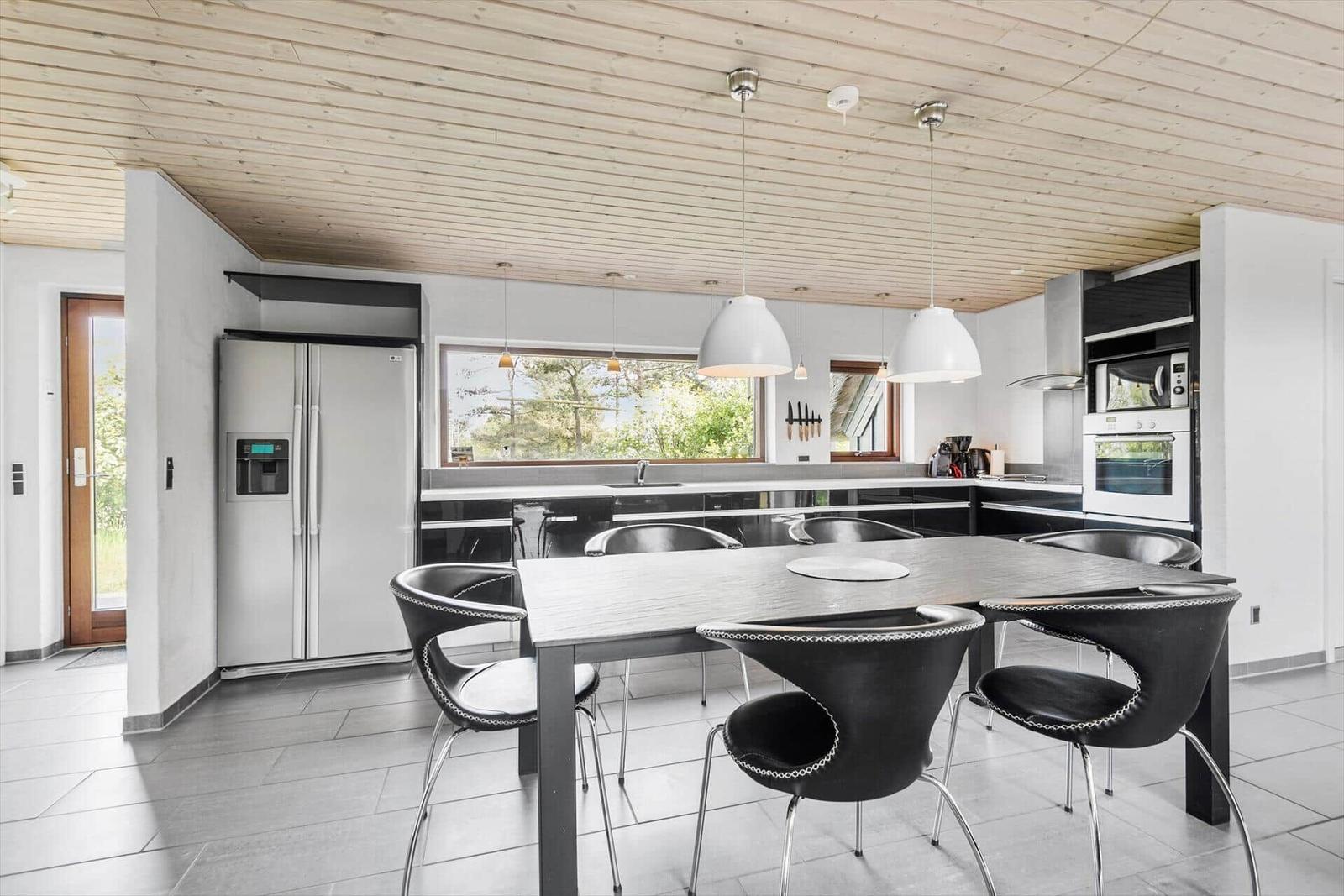 Moderne Küche mit Esstisch, Kühlschrank und Fensterblick.