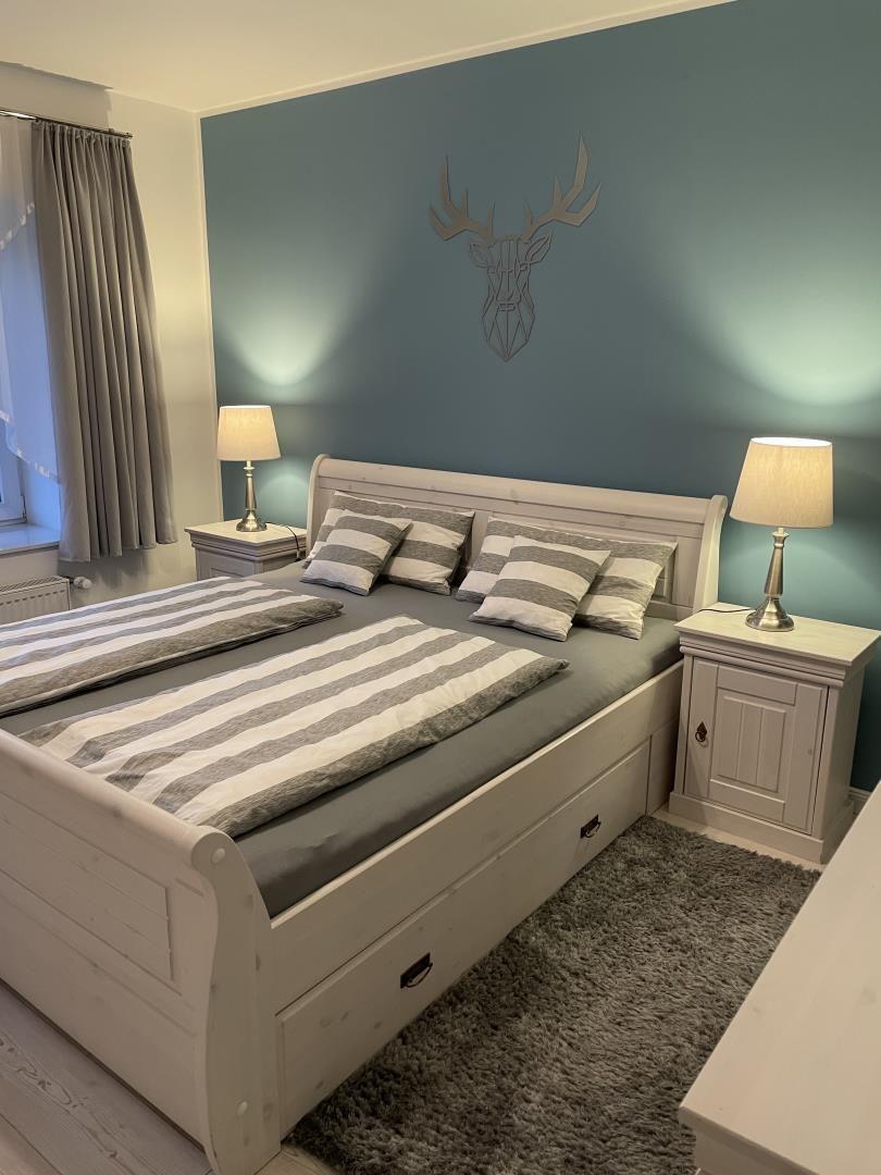 Schlafzimmer mit Bett, Nachttischen und Wanddekoration