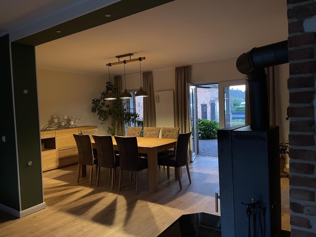 Essbereich mit Holztisch, Stühlen und Glasfront zur Außenterrasse.