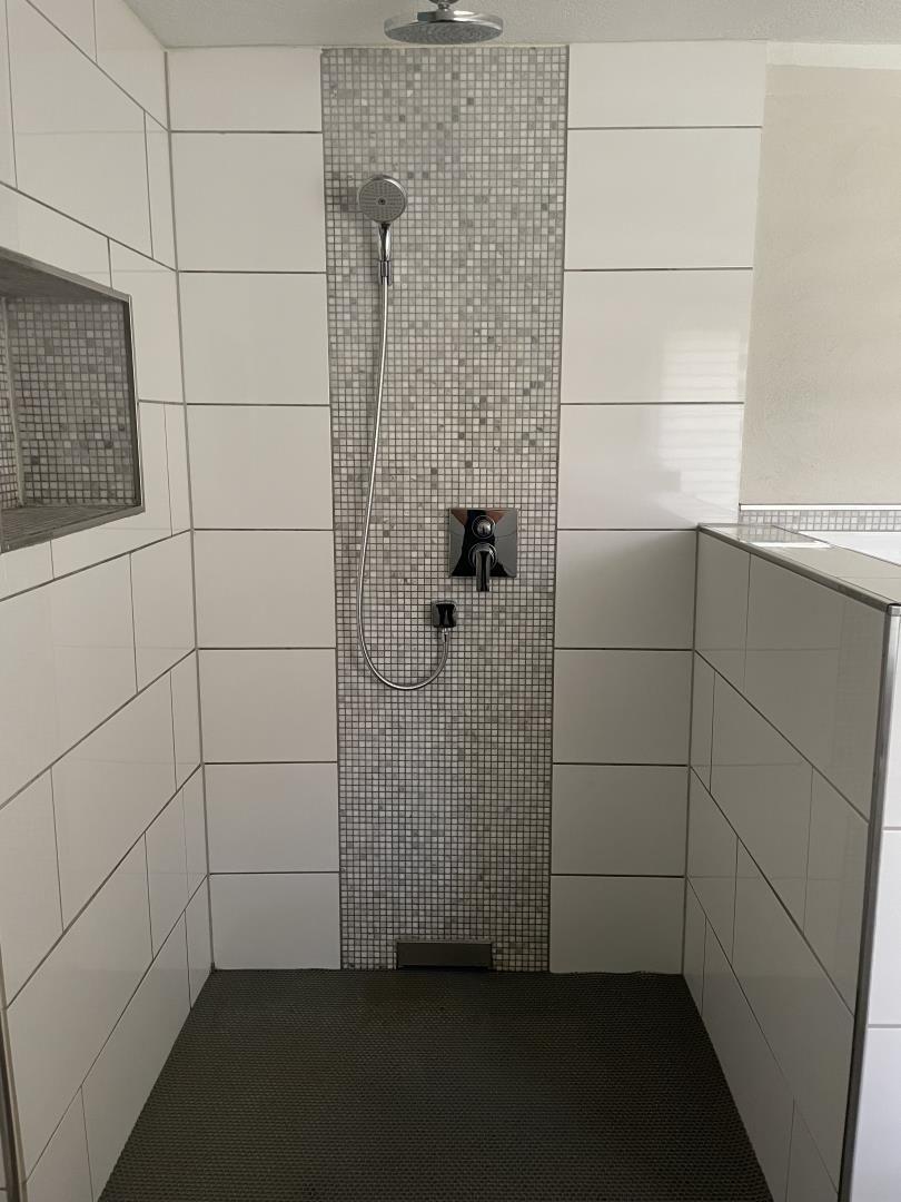 Dusche mit Duschbrause, Mosaikwand und Bodenmatte