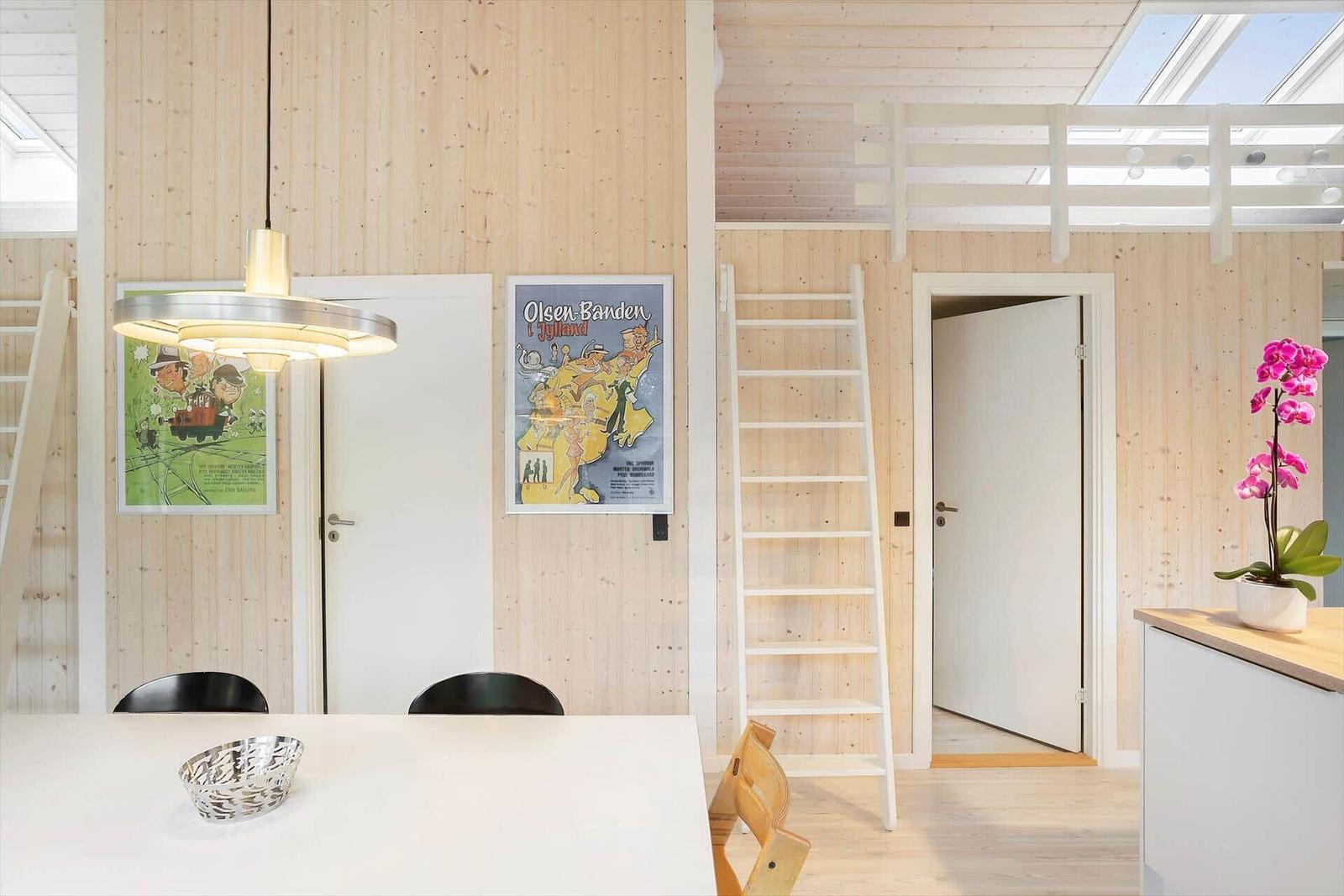 A room with wooden walls, a ladder, and two wall posters.