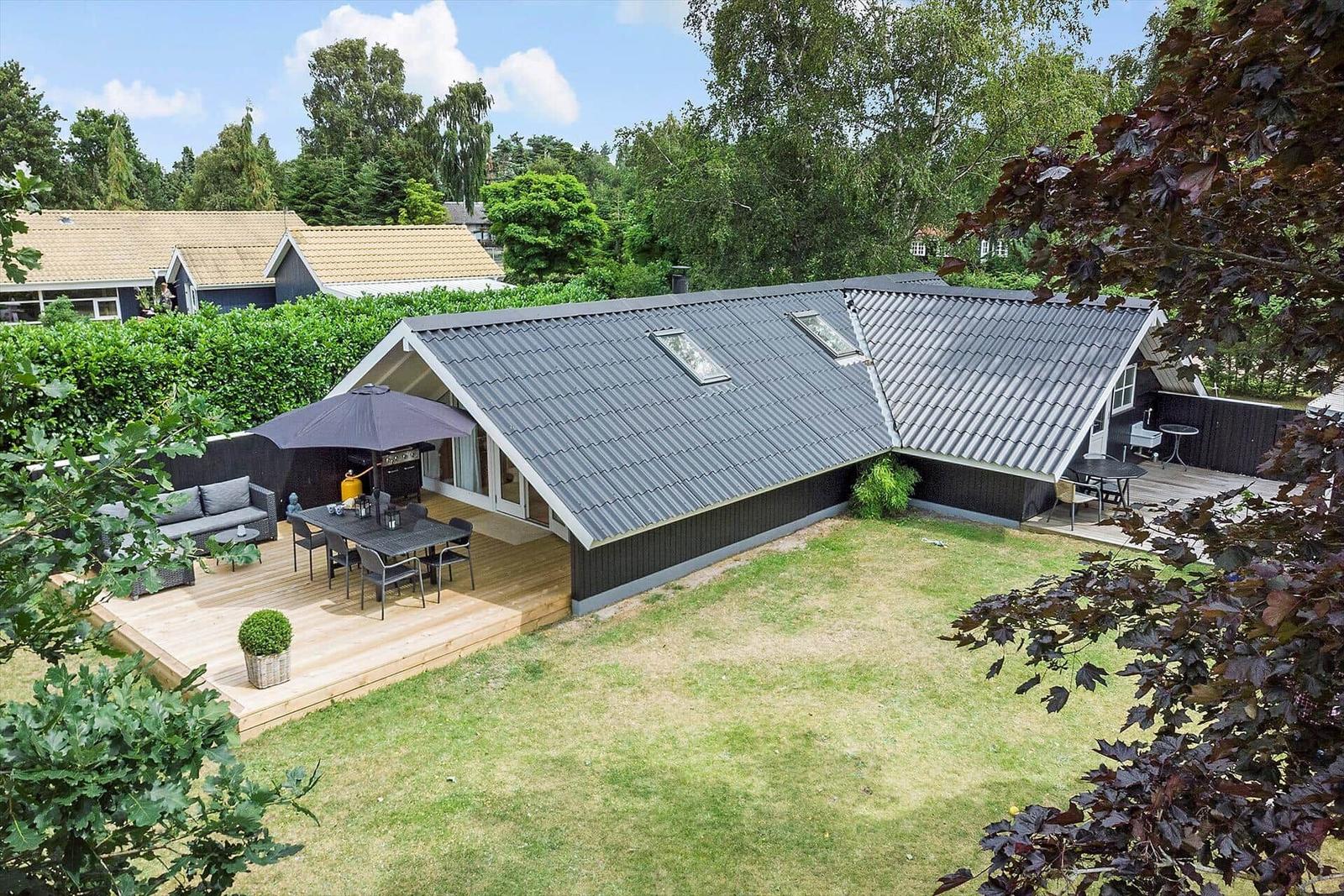 Moderne Villa mit großem Garten und Terrasse mit Sitzgelegenheiten.
