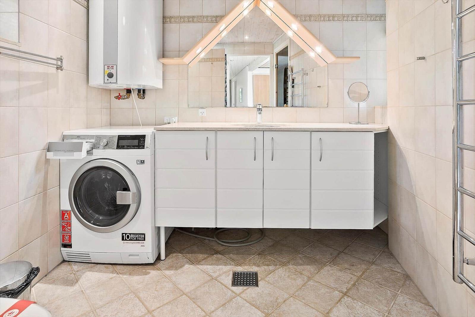 Badezimmer mit Waschmaschine, Spiegelschrank und Dusche