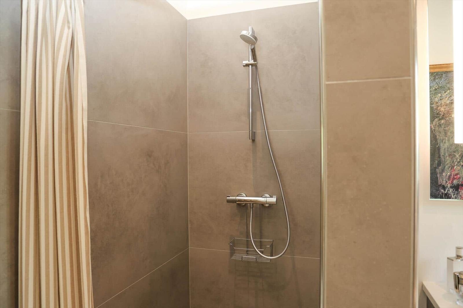 Dusche mit Duschbrause und Handbrause an Wand montiert