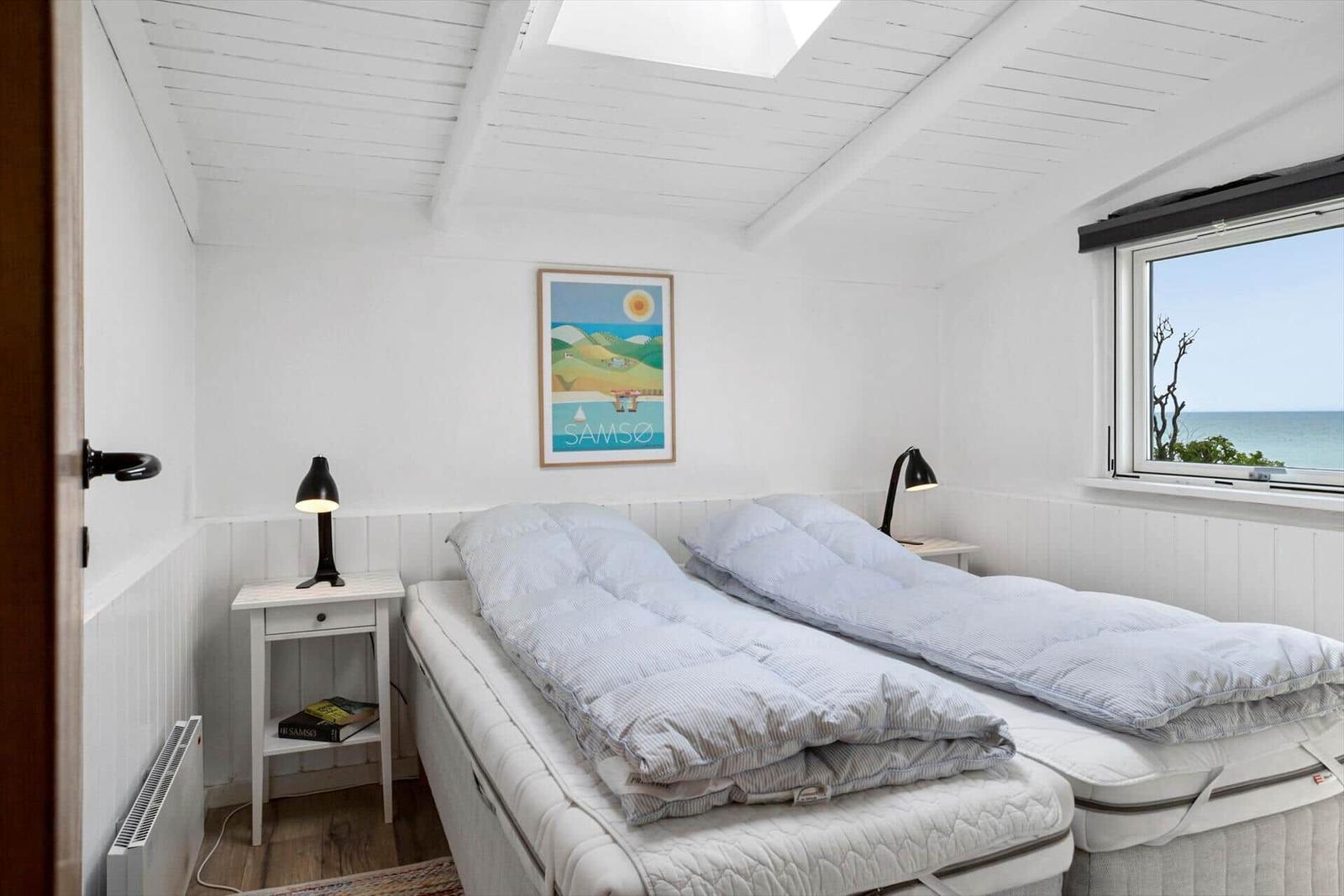 Zimmer mit zwei Betten, Fensterblick aufs Meer und Deckenfenster.
