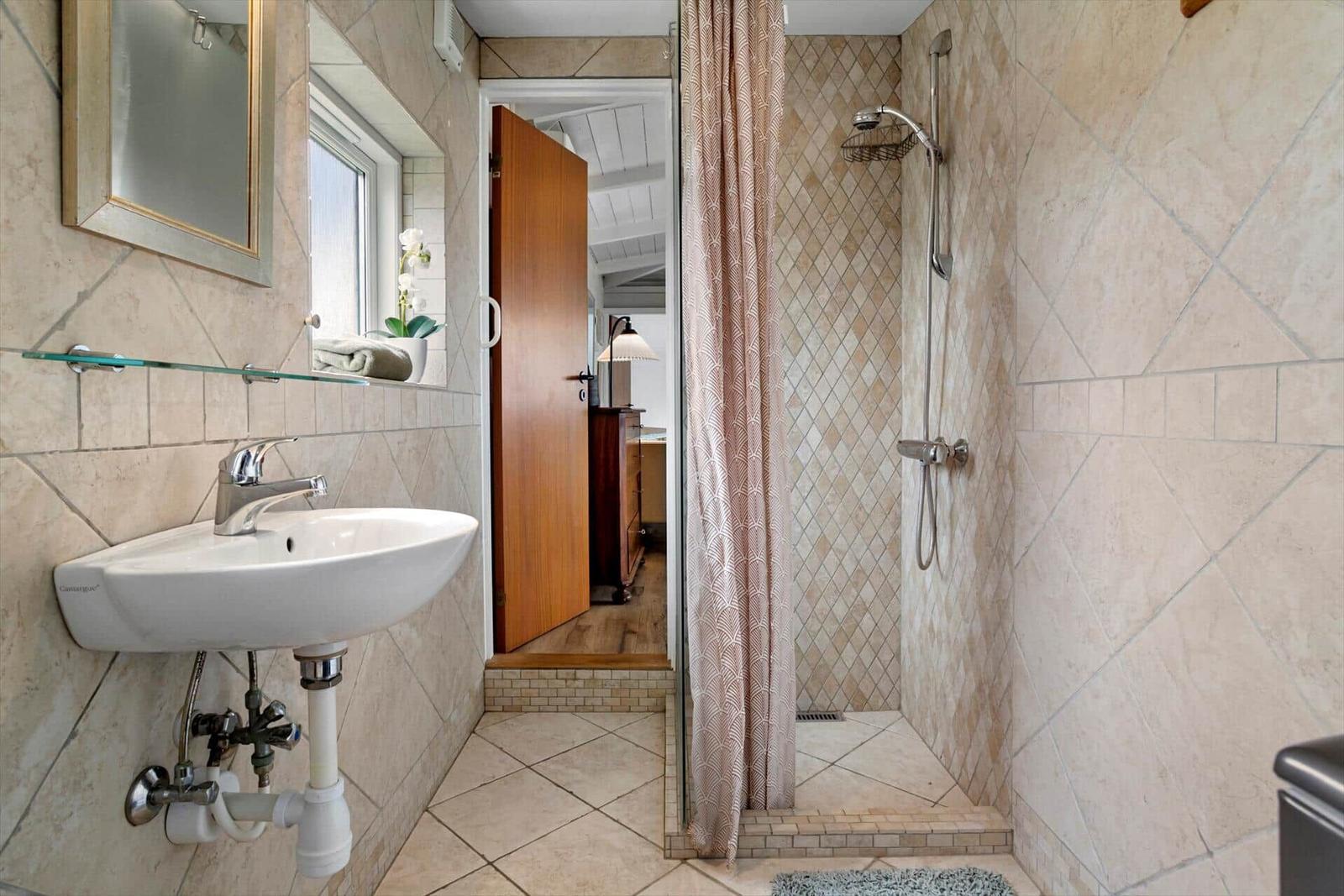 Bad mit Dusche, Waschbecken und Fenster