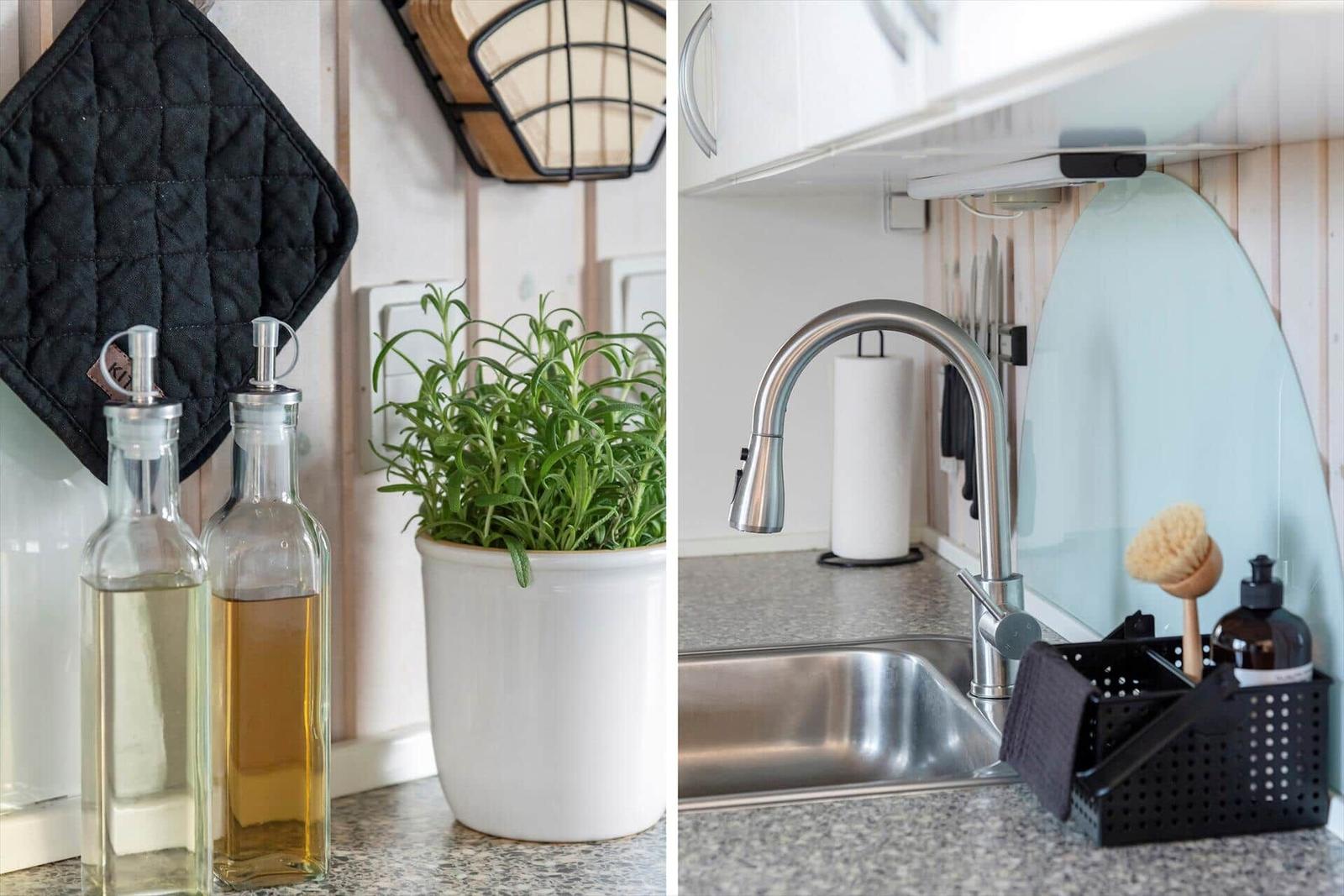 Kitchen area with olive oil bottles, rosemary, and stainless steel sink.
