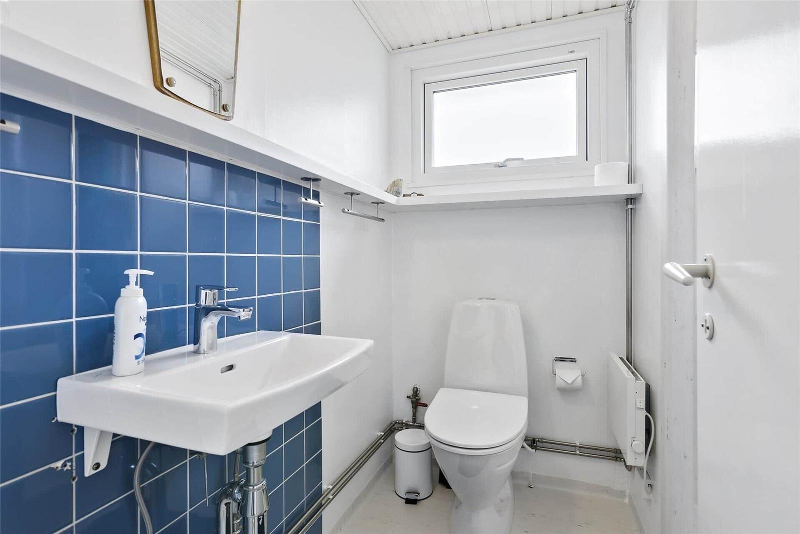 Badezimmer mit blauen Fliesen, Waschbecken und Toilette