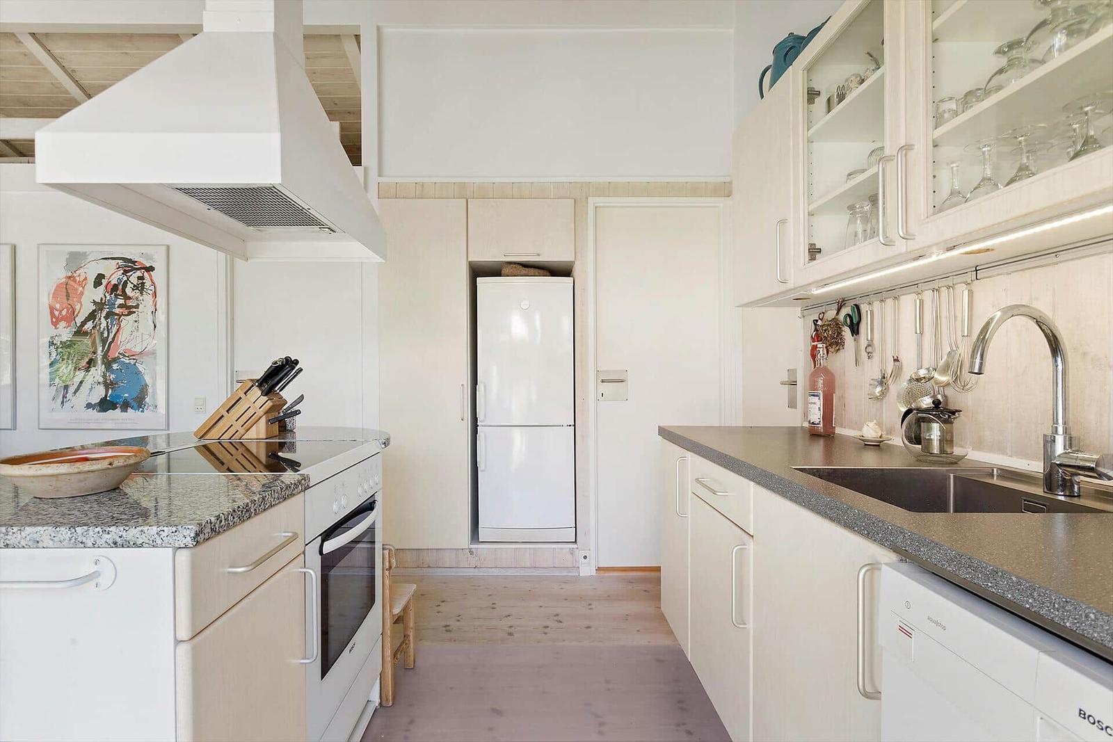 Küche mit Arbeitsplatten, Kühlschrank und Spüle
