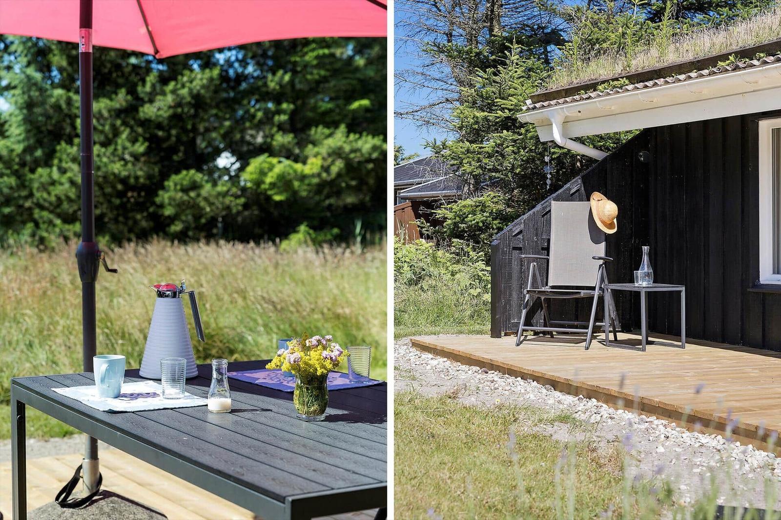 Terrasse mit Tisch, Stühlen und Sonnenschirm. Schwarzes Haus mit Dachgarten und Holzdecke.