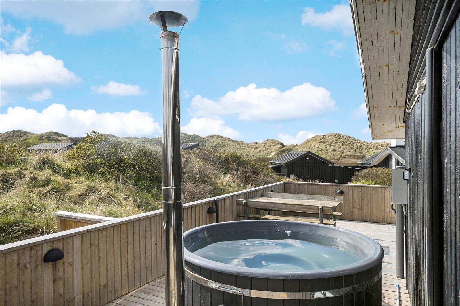 Hochwertiger Whirlpool auf Terrasse mit Blick auf Dünenlandschaft