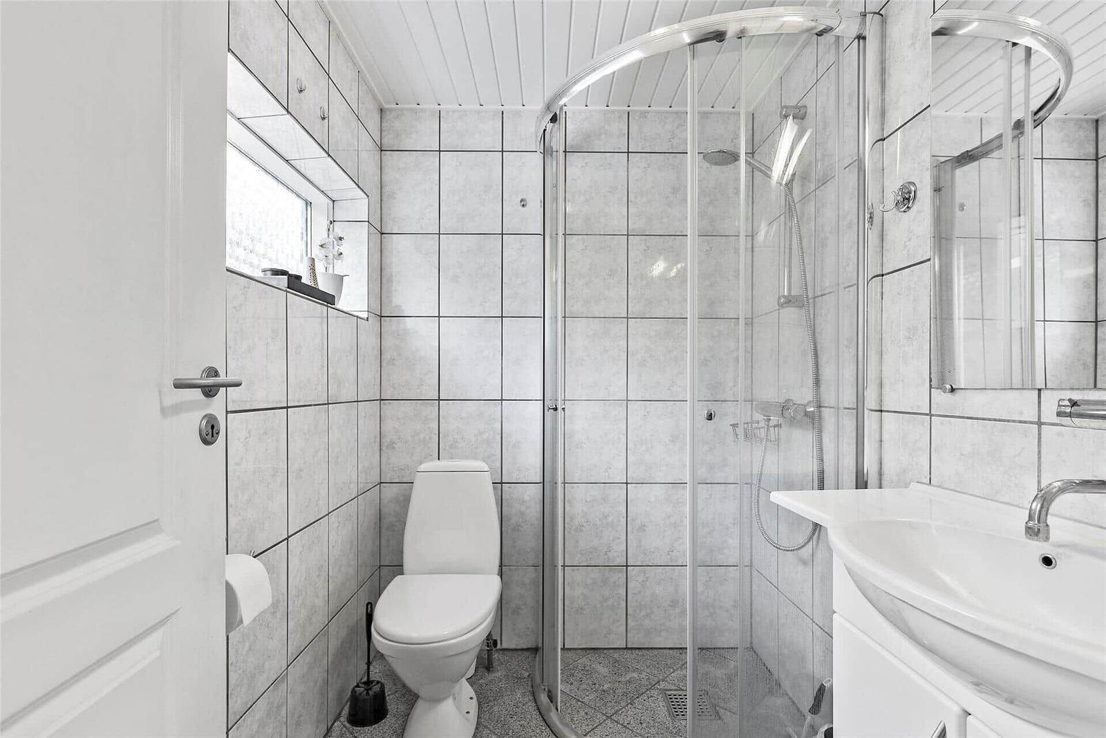 Badezimmer mit Dusche, Toilette und Waschbecken.