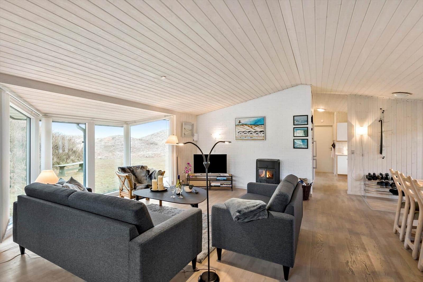 Living room with gray sofas, fireplace, and view of the landscape.