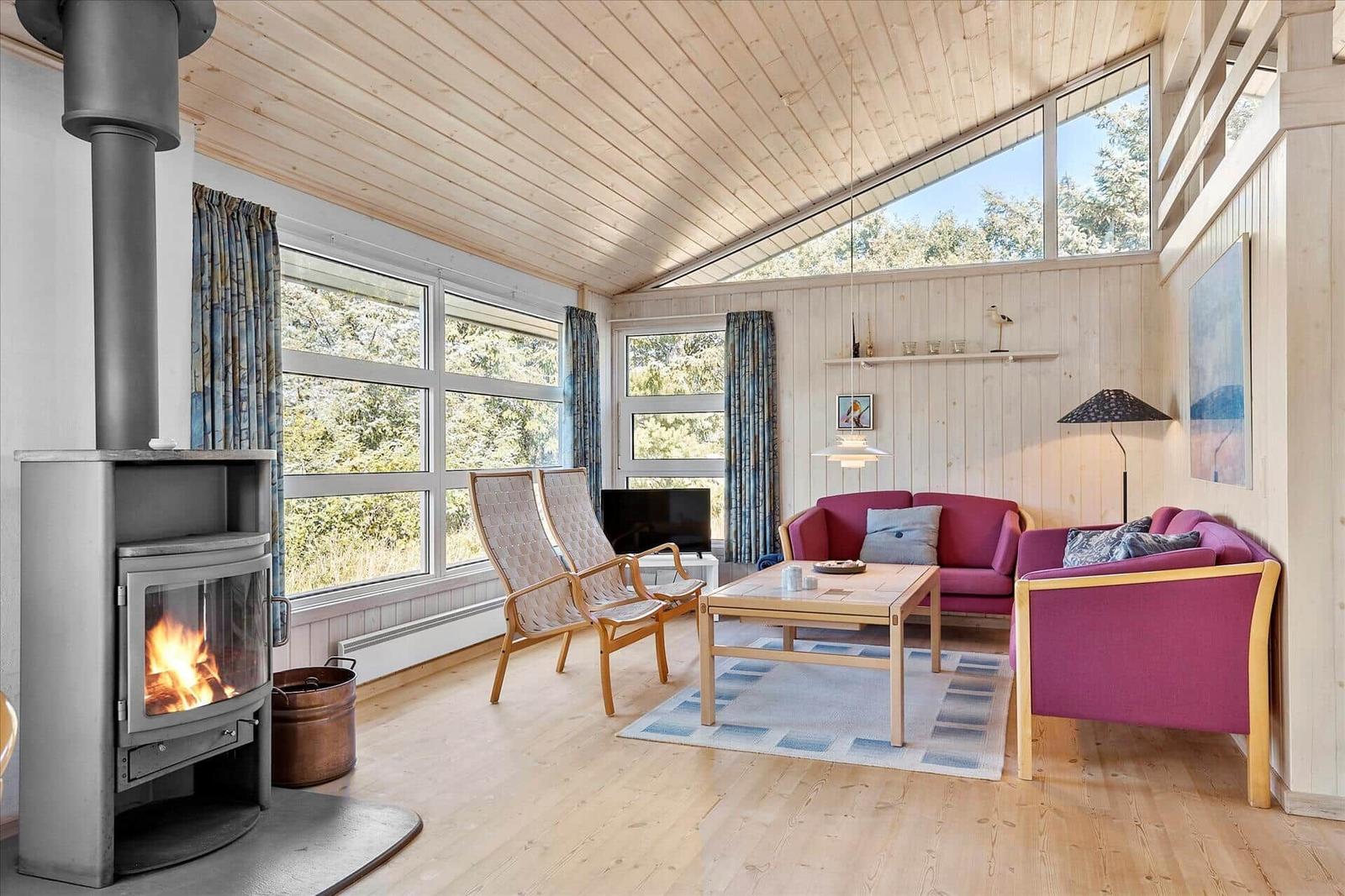 Living room with fireplace, windows, and purple sofas.