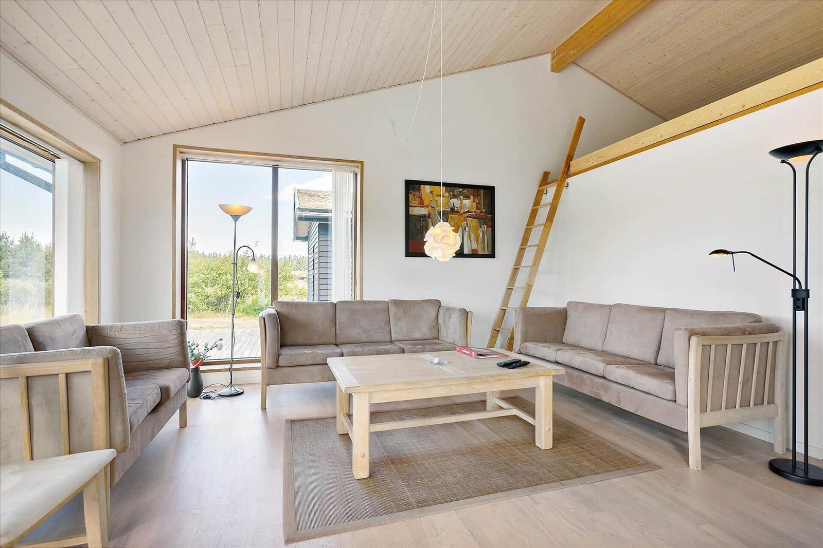 Wohnzimmer mit zwei Sofas, Tisch und Fenster zur Außenseite.