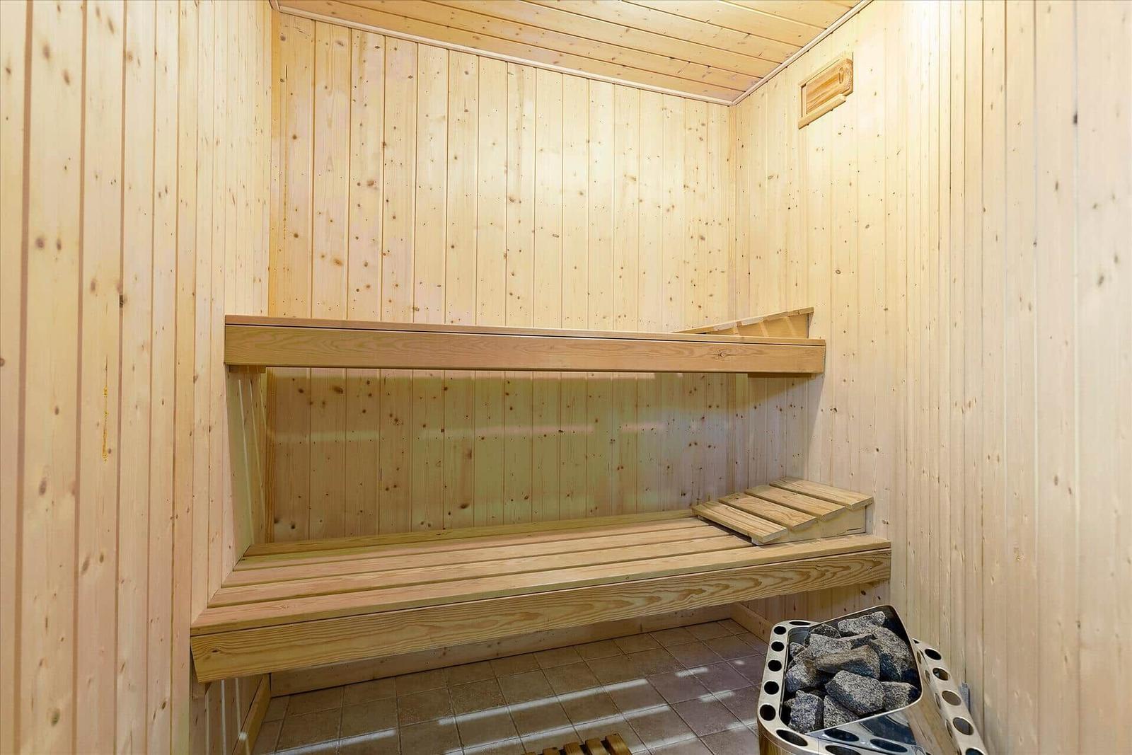 Sauna mit Holzbank und Steinbehälter