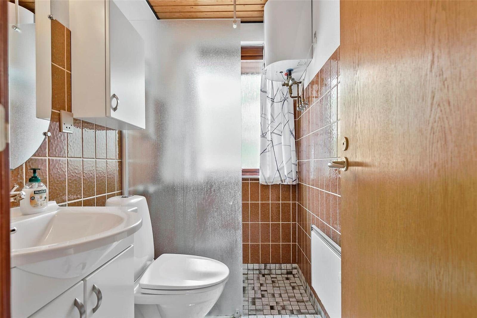 Badezimmer mit Toilette, Waschbecken und Dusche mit Duschvorhang.