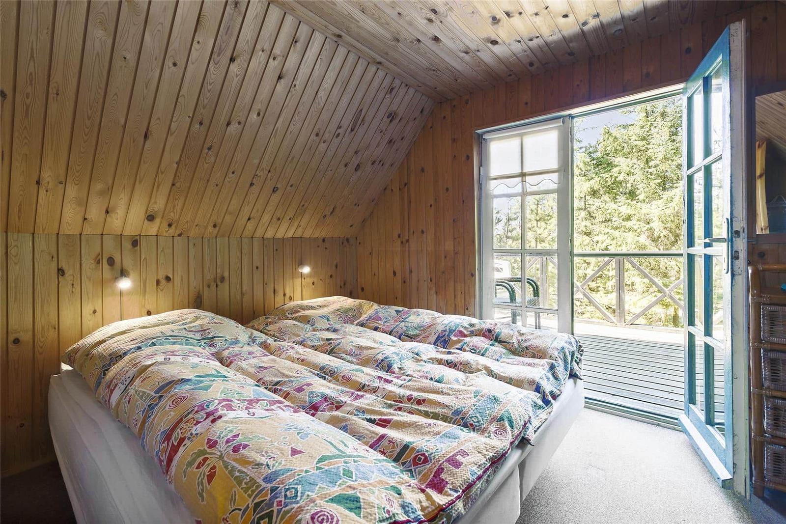 Schlafzimmer mit Holzwand und Balkonansicht