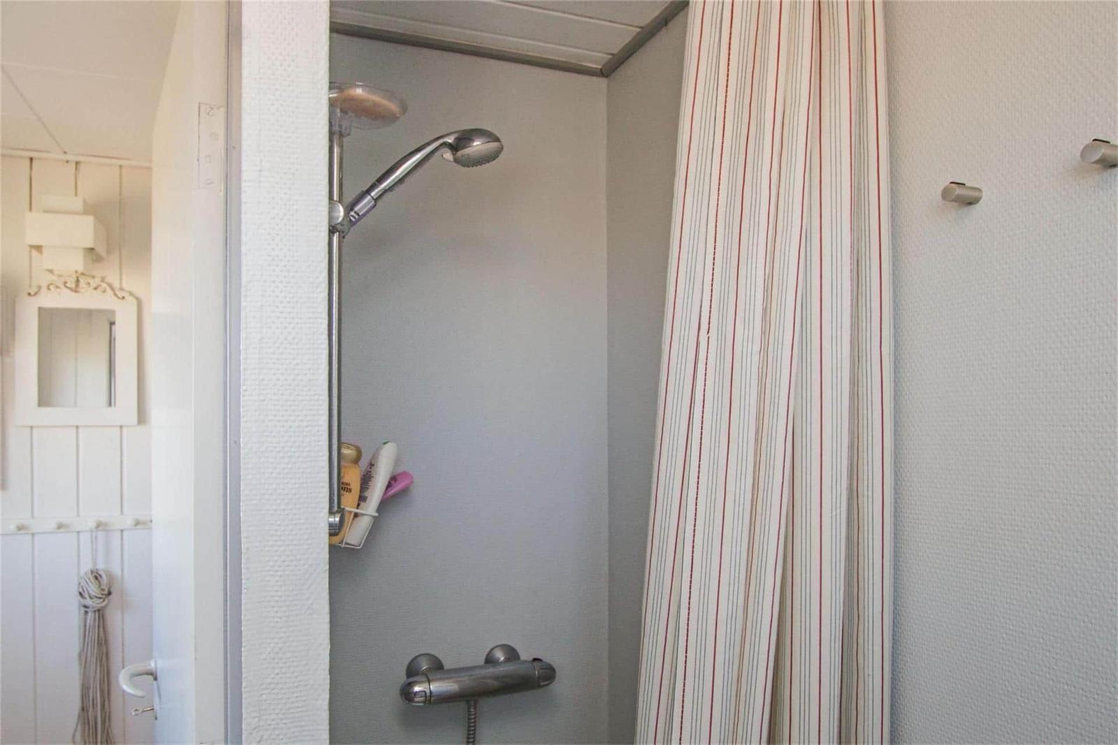 Shower with shower head and striped curtain