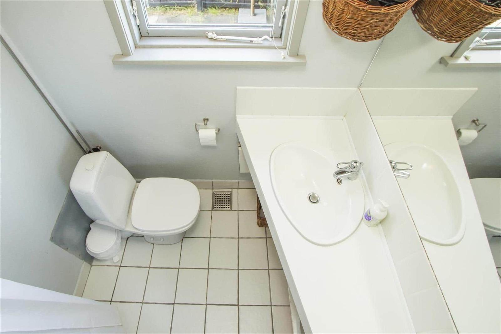 Bathroom with toilet, sink, and window