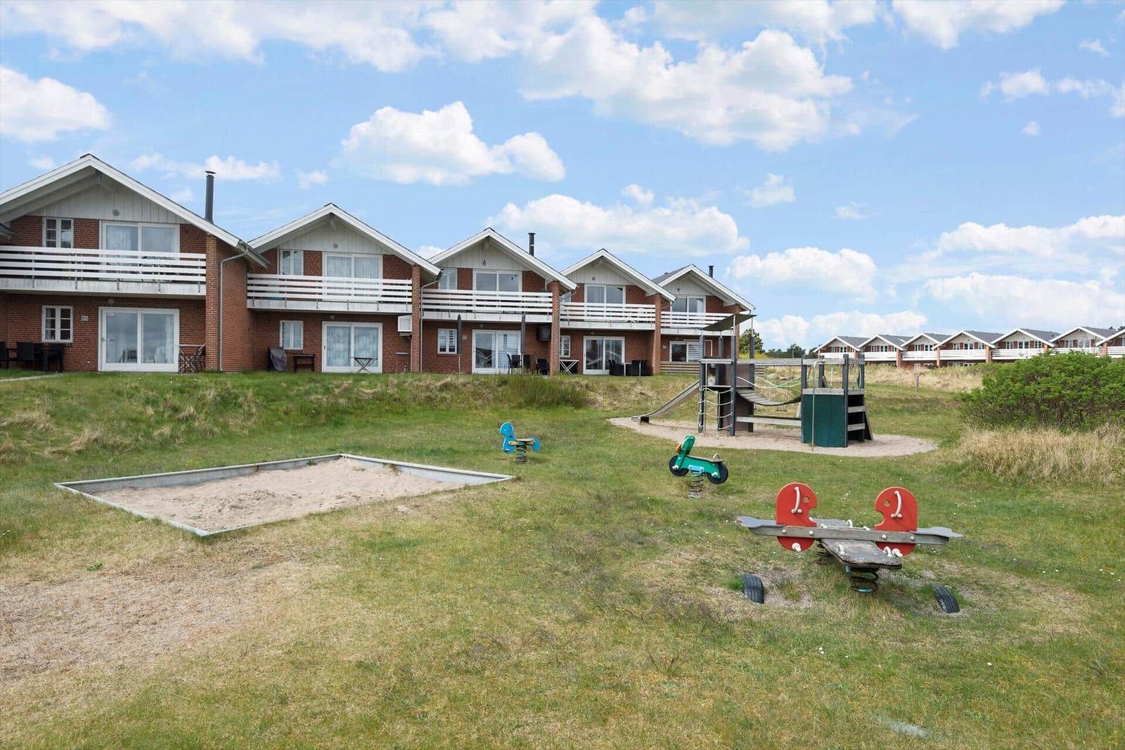 Row houses with balconies and outdoor playground.