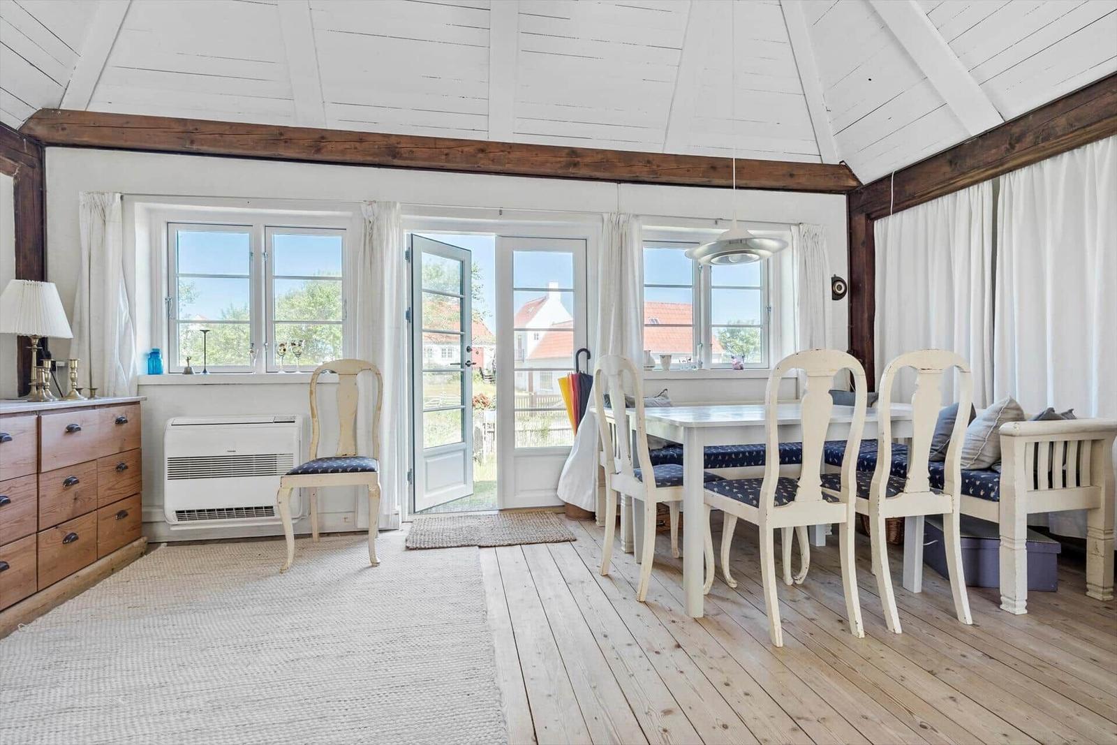 Esszimmer mit Tisch, Stühlen und Blick auf den Garten.
