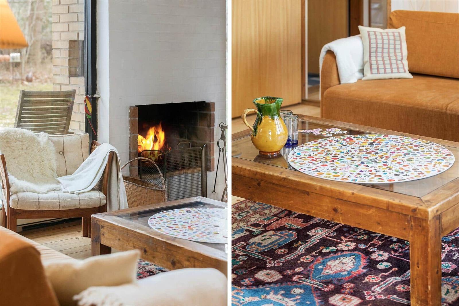 Ein Kamin mit brennendem Feuer und ein Wohnzimmer mit Couch und Tisch.