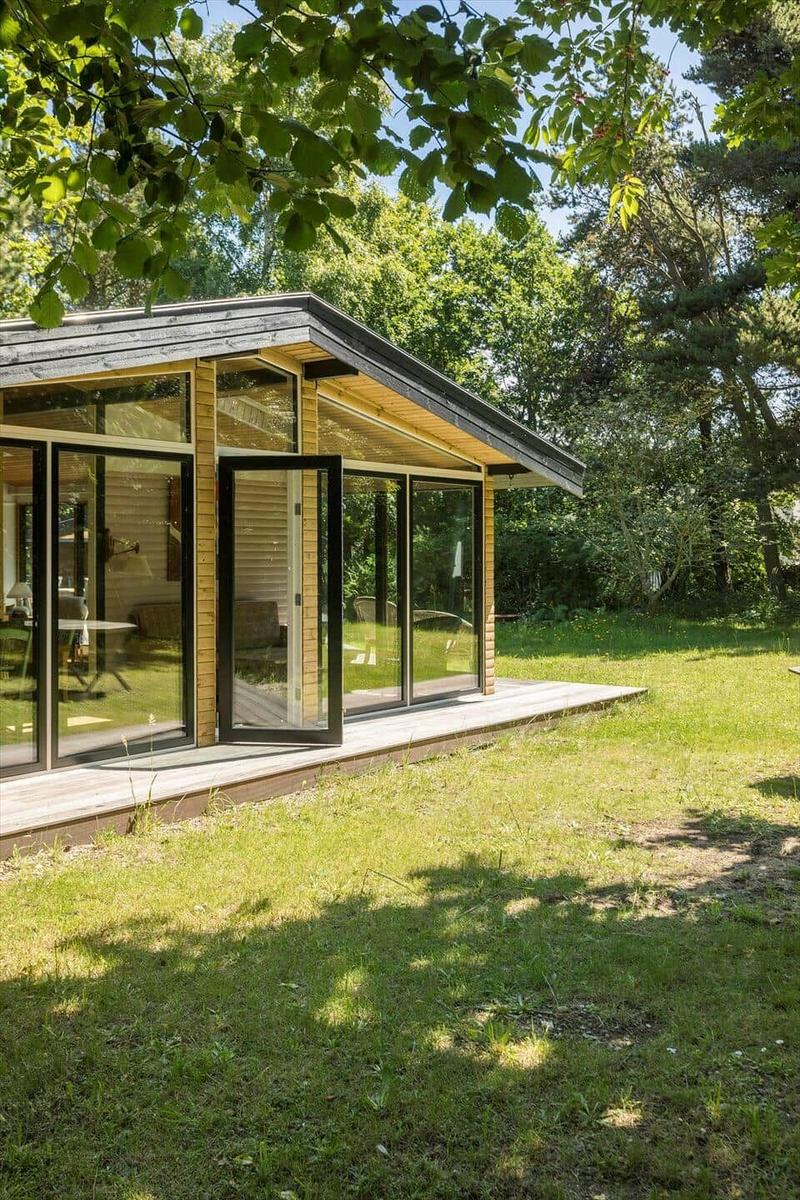 Moderne Holzhütte mit großem Glasbereich im Grünen