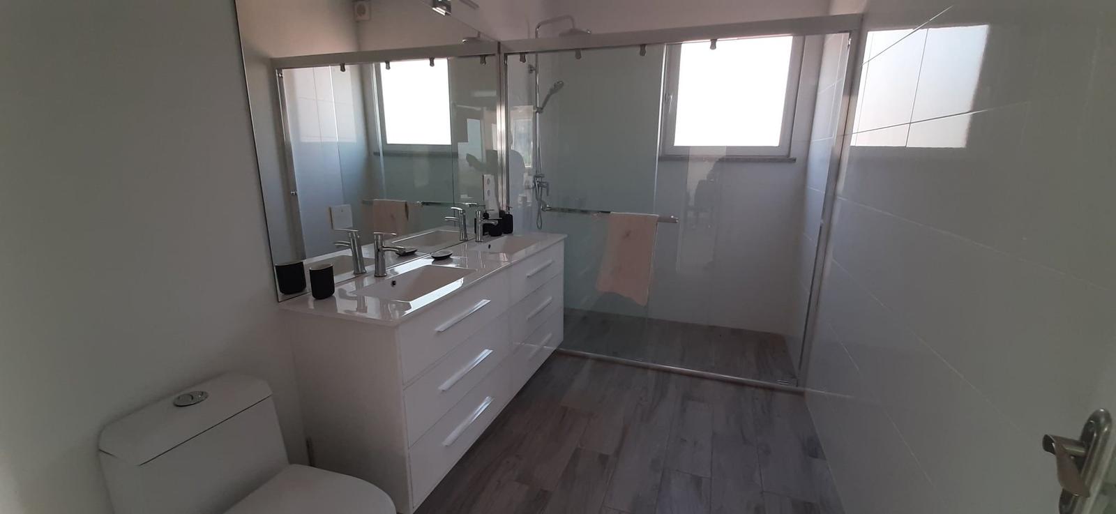 Badezimmer mit Dusche, Waschbecken und Toilette