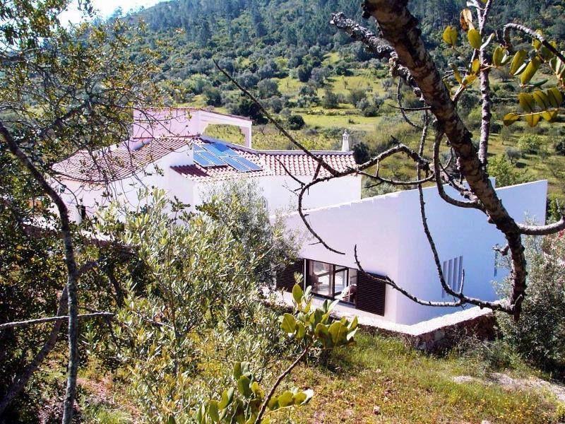 Weiße Villa mit Solaranlage in grüner Berglandschaft