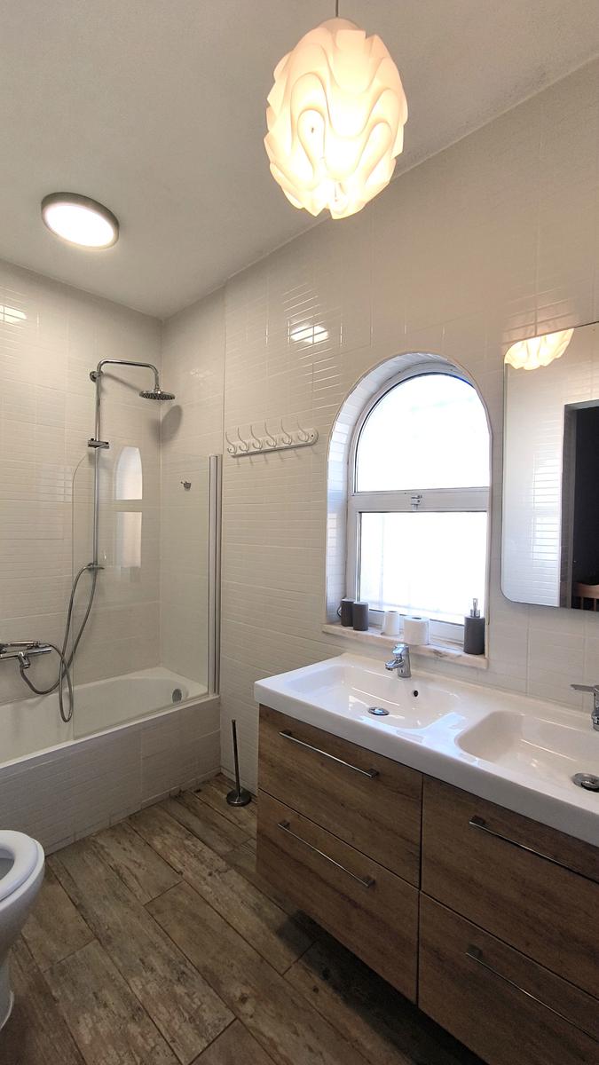 Badezimmer mit Dusche, Waschbecken und Holzboden