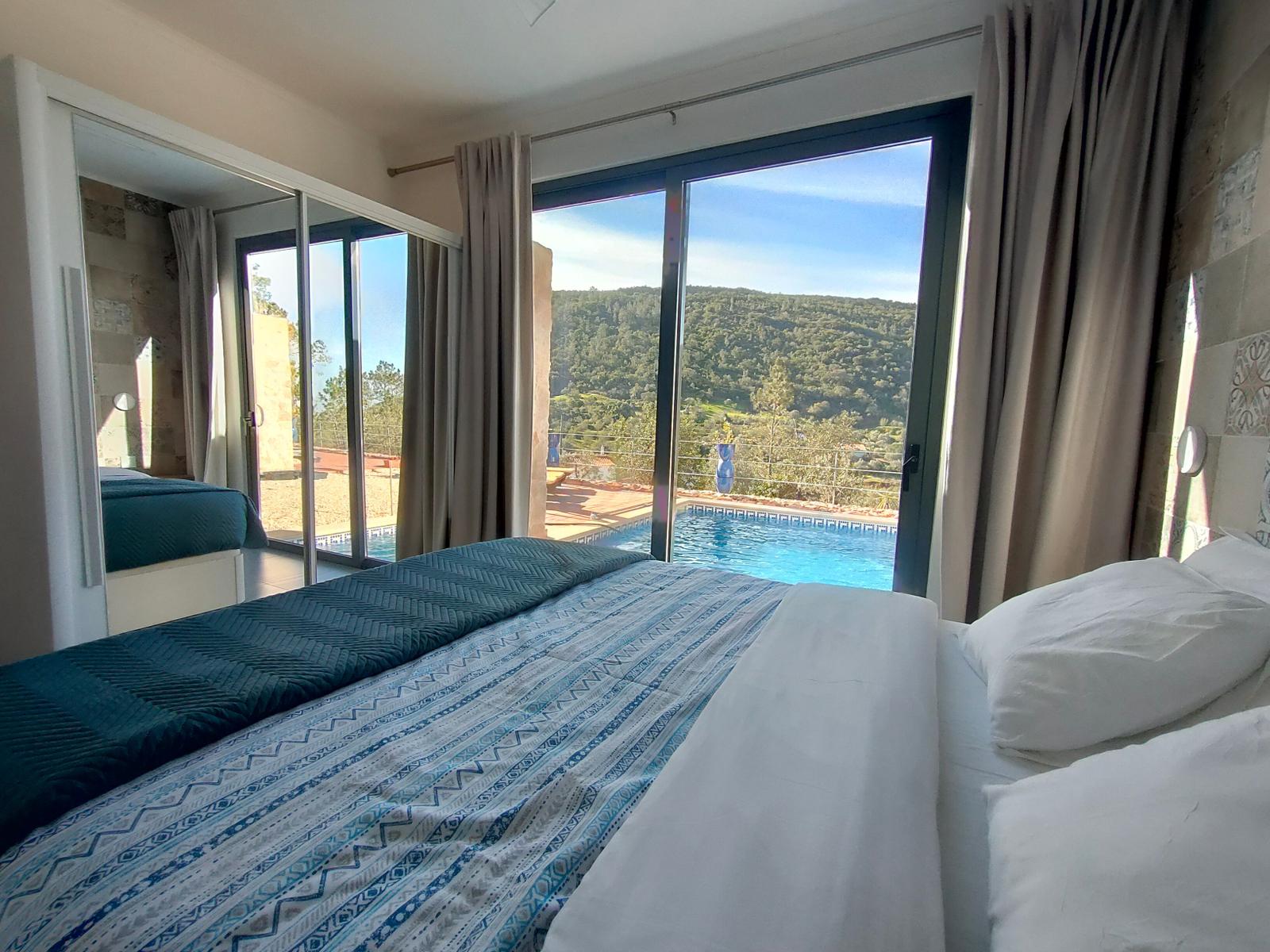 Schlafzimmer mit Blick auf Pool und Hügel