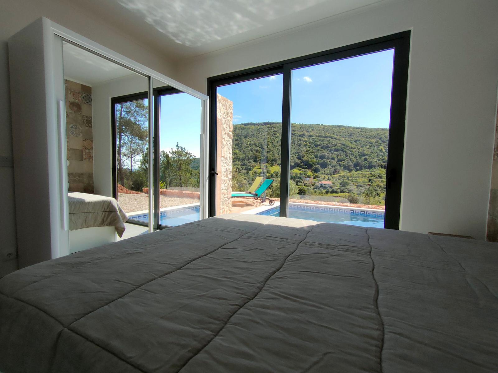 Schlafzimmer mit Blick auf Pool und Landschaft