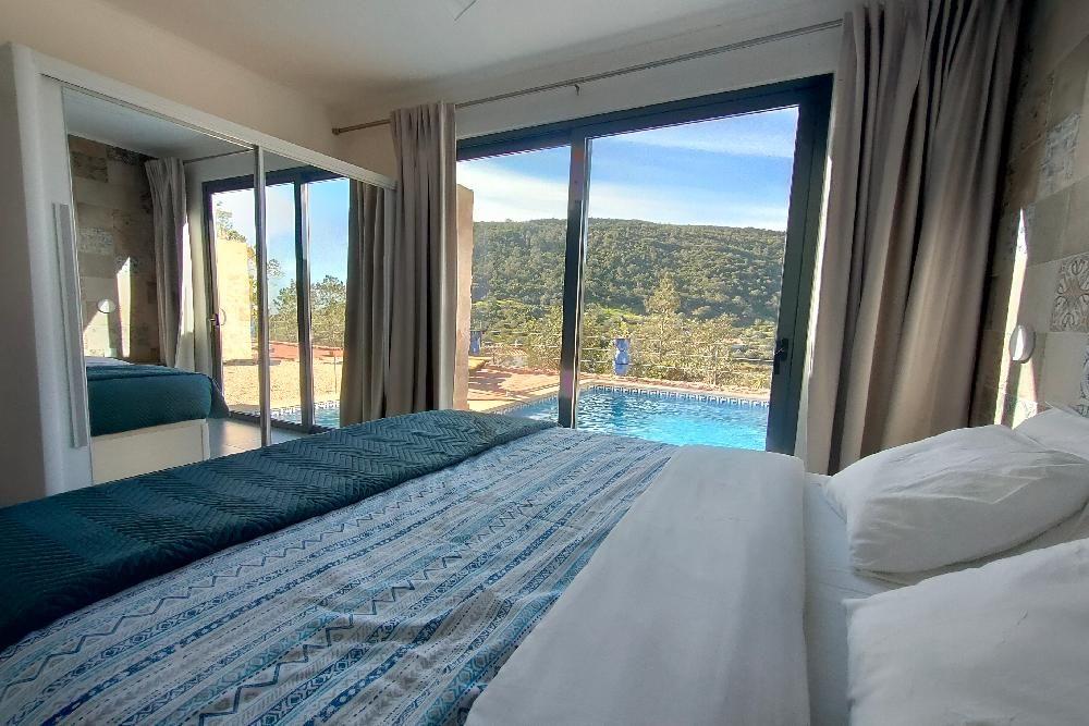 Schlafzimmer mit Blick auf Pool und Landschaft