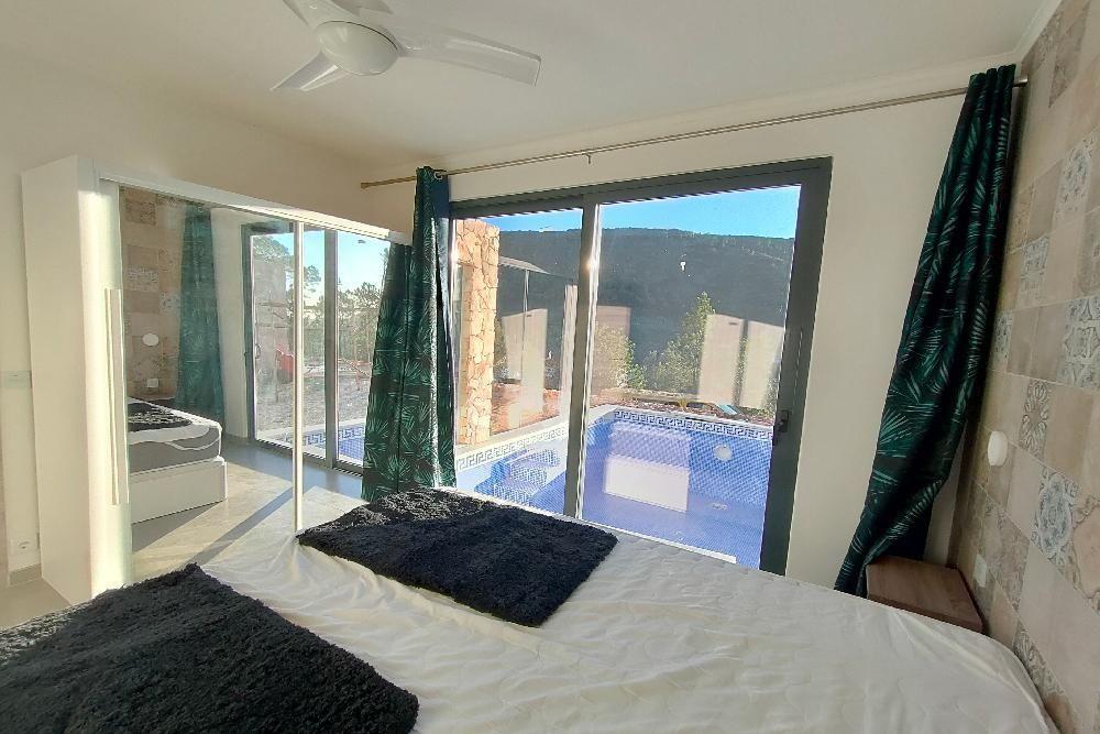 Schlafzimmer mit Blick auf Pool und Terrasse