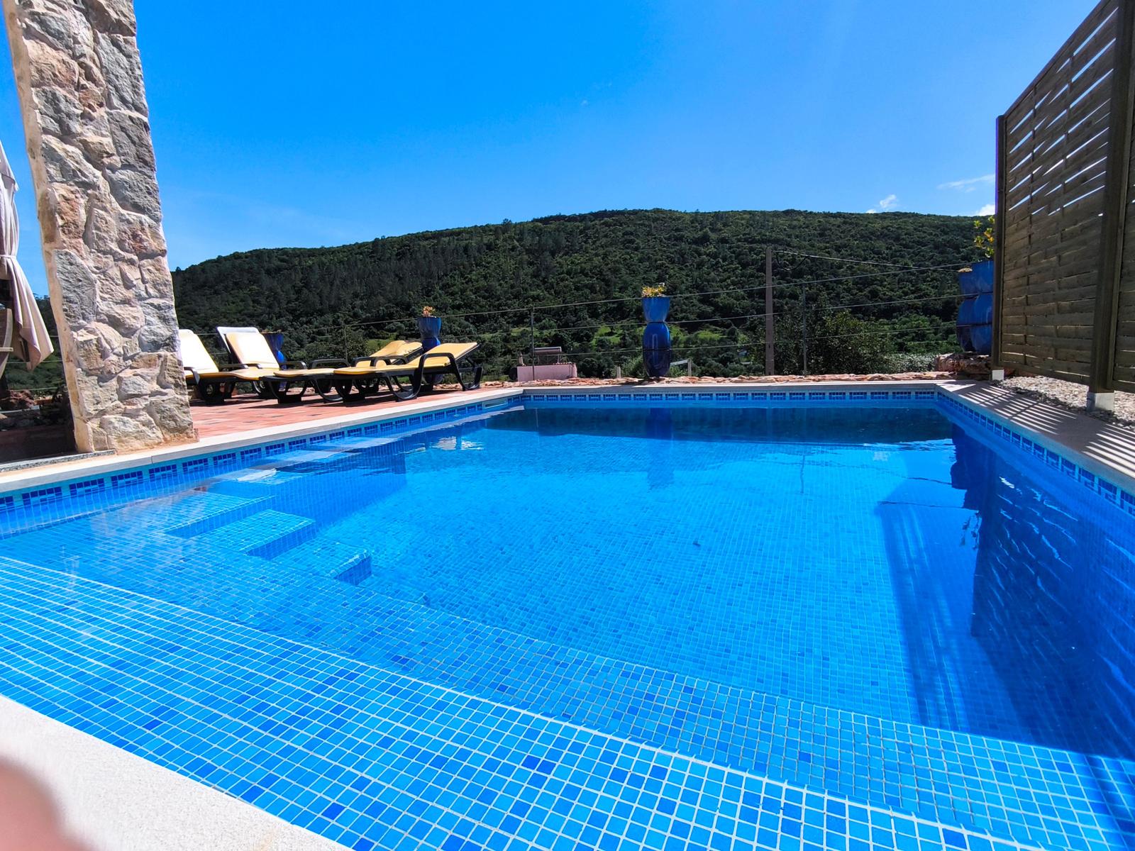 Pool mit Liegestühlen und Bergblick