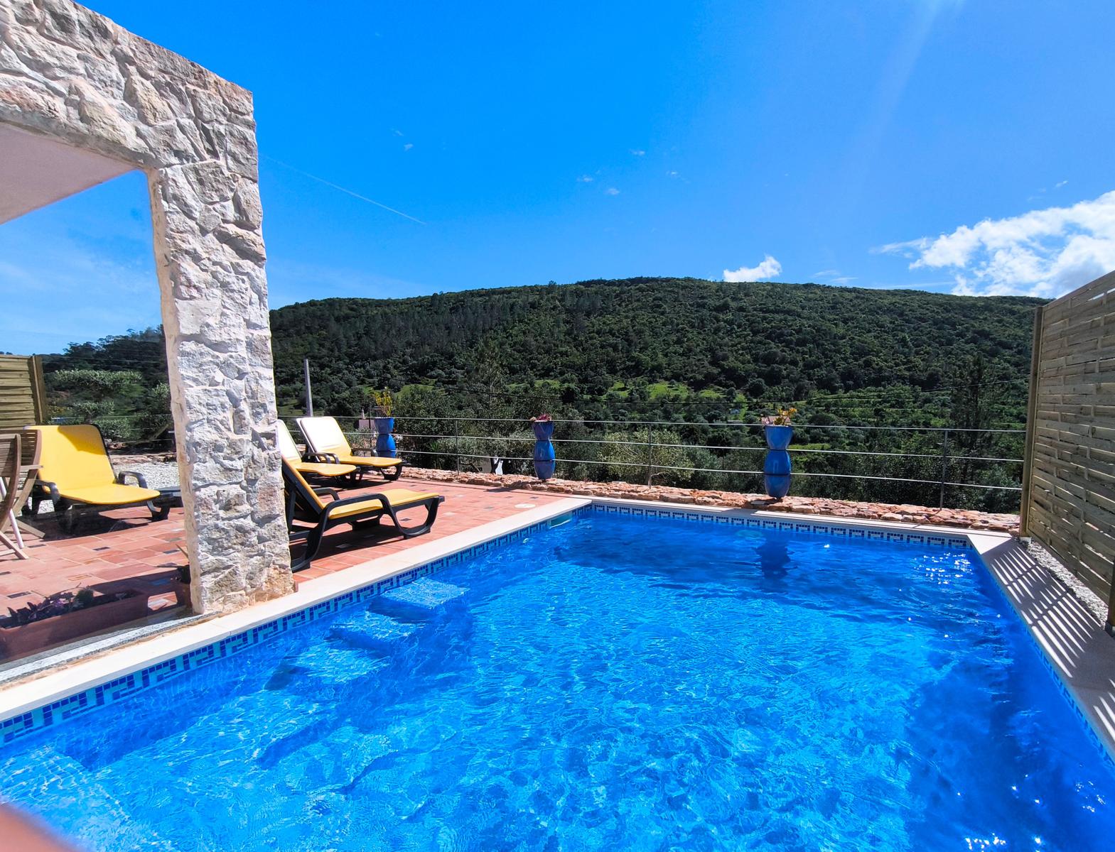 Pool mit Liegestühlen und Bergblick