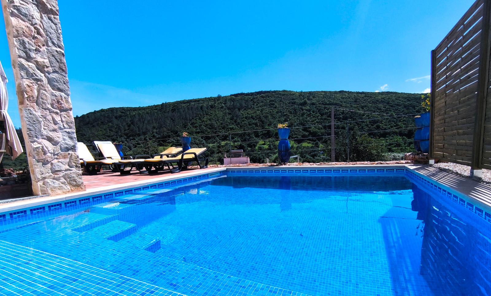 Pool mit Liegestühlen und Bergblick