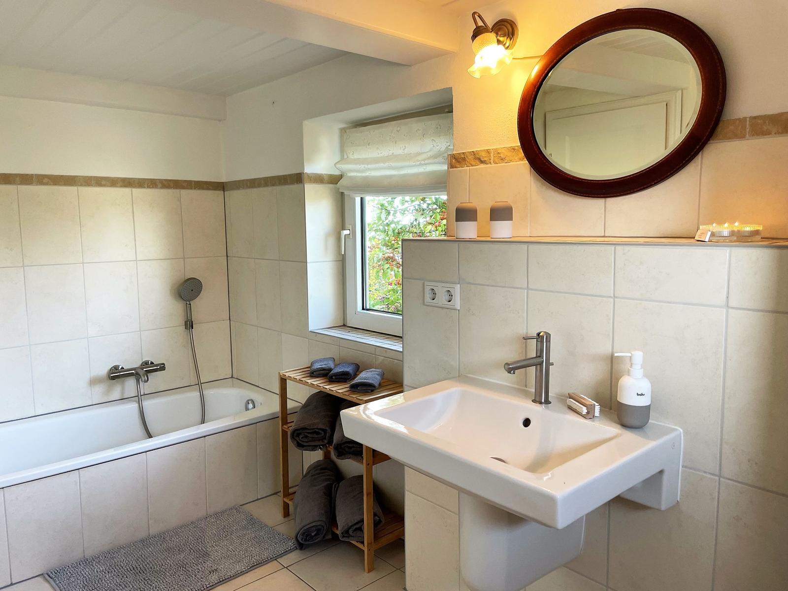 Bathroom with bathtub, sink, and wooden towel rack.