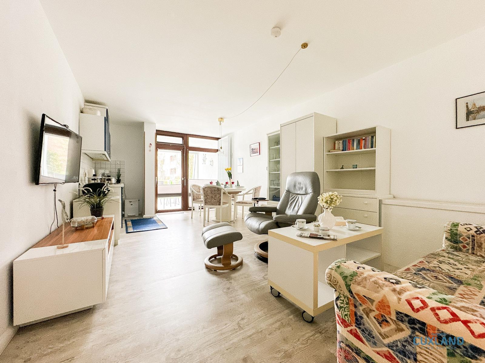 Wohnzimmer mit Essbereich, Fernseher und Schlafbereich.