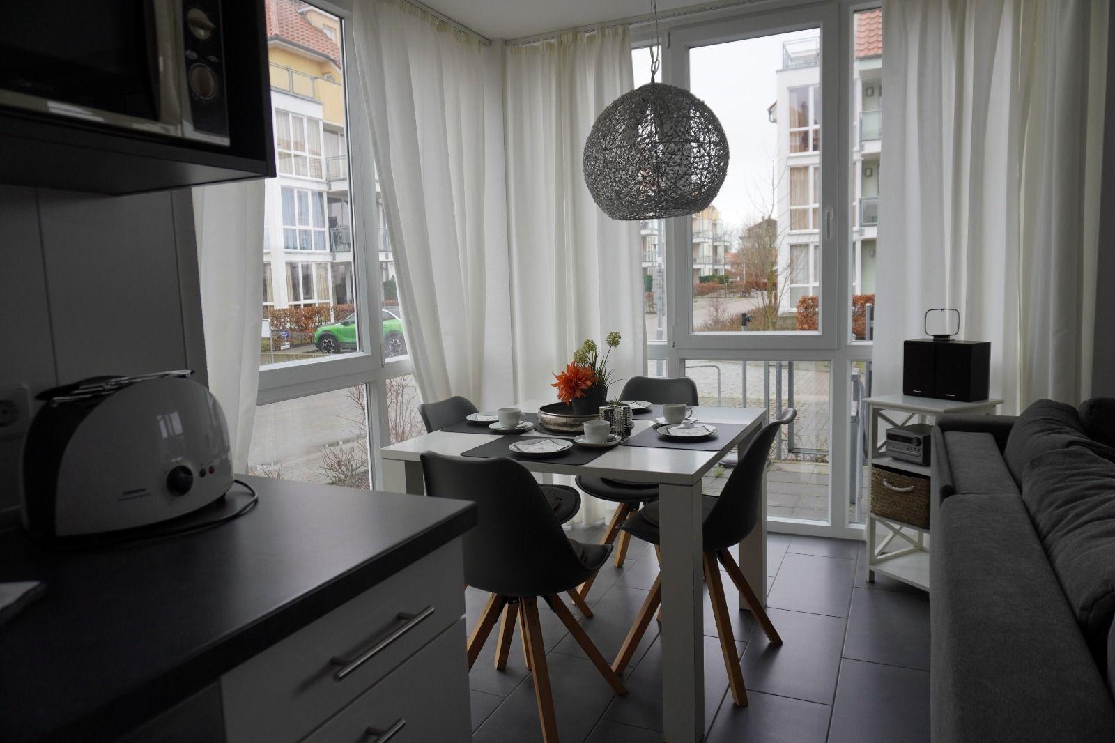 Essbereich mit Tisch, Stühlen und Fensterblick auf Balkon