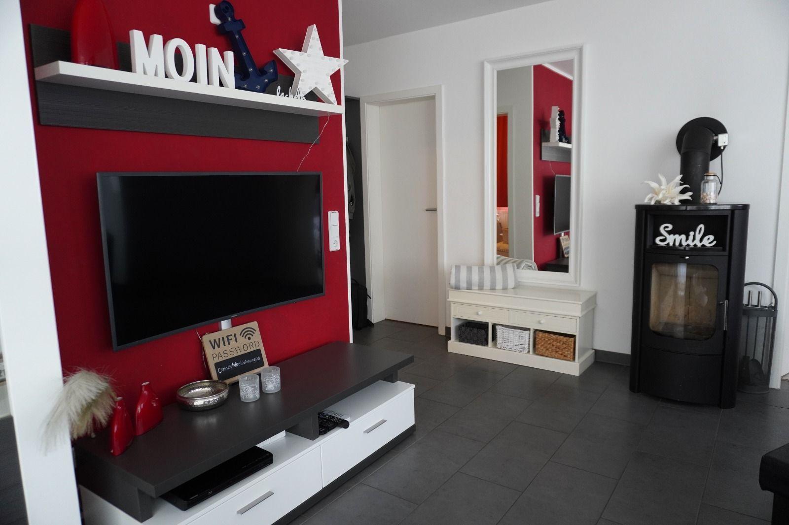 Wohnzimmer mit Fernseher, Kamin und Spiegel