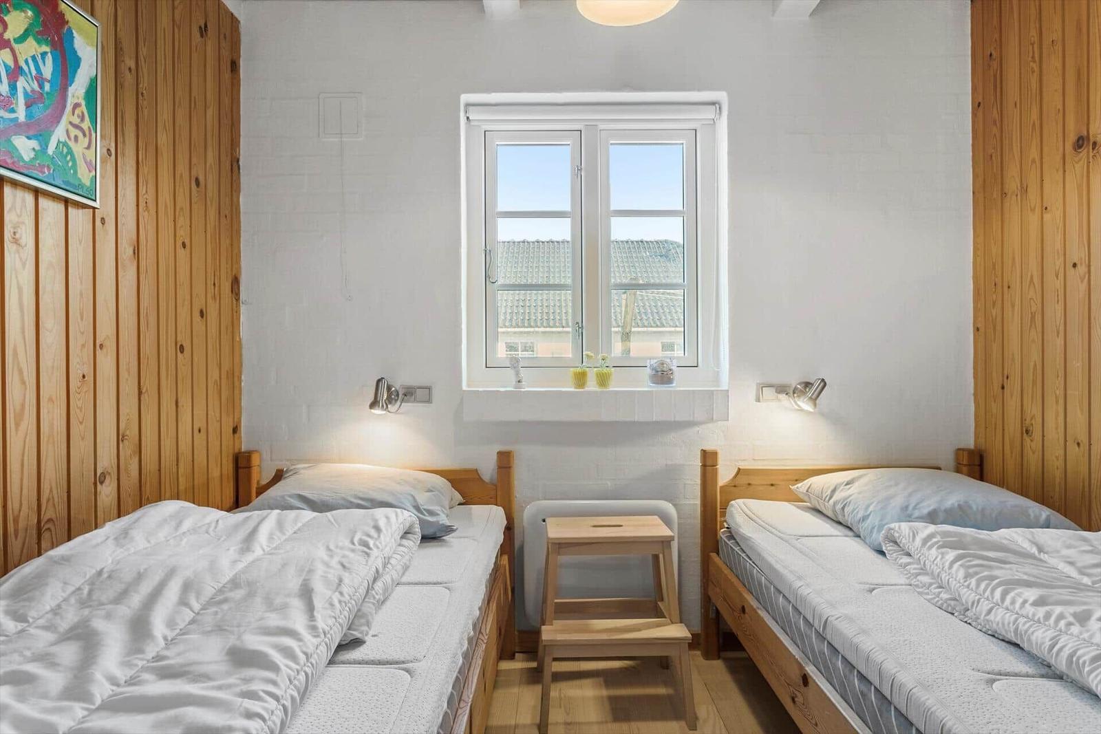 Zwei Schlafzimmer mit Holzbetten und Fenster zur Aussicht.